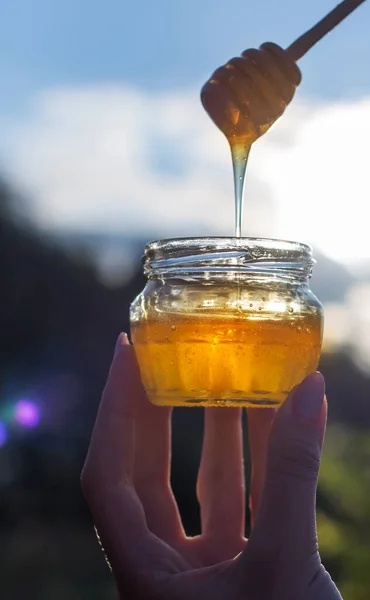 Διαφανές Κίτρινο Μέλι Από Ένα Κουτάλι Χύνει Ένα Βάζο Ενάντια — Φωτογραφία Αρχείου