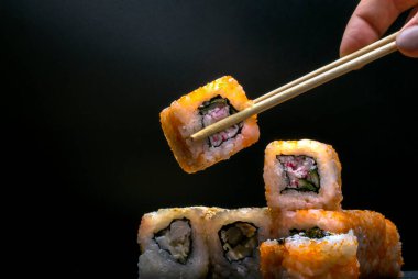 Japon mutfağı, siyah arka planda yengeç etli pirinç ruloları..