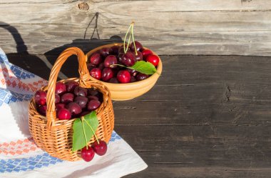 Güneşin parlak sabahında bir sepetin içindeki kirazlar uzayın bir kopyasıyla.