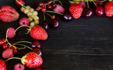 Çeşit çeşit böğürtlen koyu ahşap arka planda serilmiştir. Üst manzarada boşluğun bir kopyası vardır..
