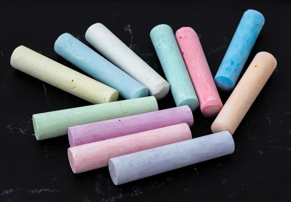 Colored chalk on a dark children\'s drawing Board.
