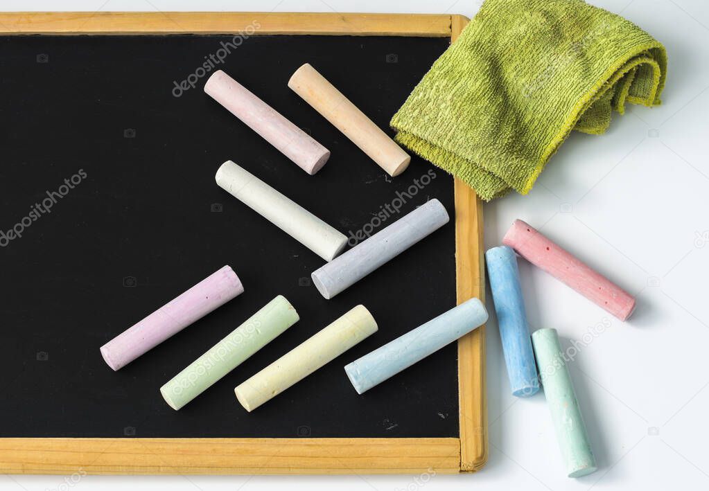 children's black blackboard with chalk and a rag on a white background.