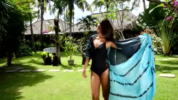 Bella giovane donna asiatica che indossa bikini e kimono spiaggia estiva o pareo pareo nel giardino tropicale. Vacanze estive — Video Stock