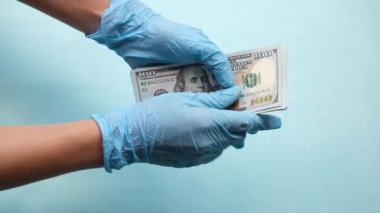 Hasta, doktora rüşvet veriyor. Mavi arka plan üzerinden doktora para veren ellerin yakınlaşması. Doktor ilaç yazmak için rüşvet alıyor, sahte tıbbi raporlar yazıyor.
