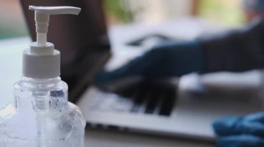 İşçi pandemik salgın sırasında Corona virüsü covid-19 'a karşı korunmak için dizüstü bilgisayarı ve klavyeyi antibakteriyel ıslak mendillerle dezenfekte eder ve temizler. İş yerinde veya evde hijyen ve virüs önleme