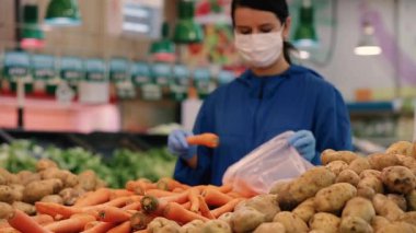 Genç kadın süpermarkette ya da mağazada alışveriş yaparken Coronavirus covid-19 'a karşı tıbbi maske ve koruyucu eldiven takıyor. Sağlık, güvenlik ve salgın konsepti.