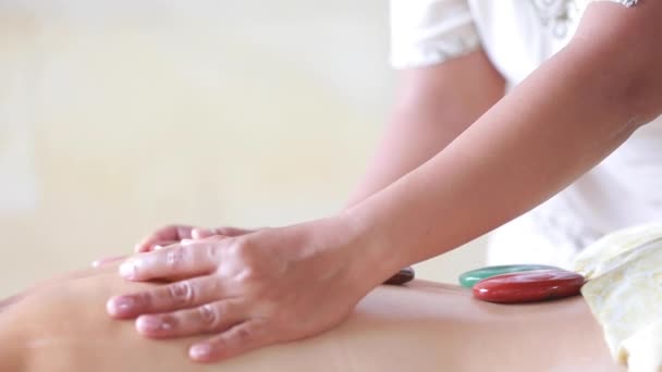Vrouw krijgt hete stenen massage in spa salon. Schoonheidsbehandeling concept. vrouw genieten van een rug massage met hete steen in een spa centrum — Stockvideo