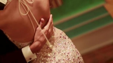 Birbirlerine aşık genç ve güzel bir çift resmi kıyafetler giyip içeride dans ediyorlar. Romantik gelin ve damat düğünlerinde dans ediyorlar.