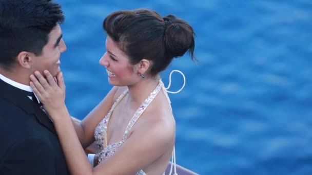 Romántica pareja joven disfrutando de la vista al mar desde la cubierta abierta en barco de crucero. Amantes felices o novia y novio vestidos elegantes y formales de vacaciones o celebrando la vela de la boda y disfrutando del romance — Vídeo de stock