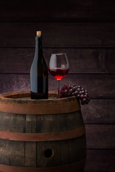 Rotweinflasche und Weinglas auf Holzfass — Stockfoto