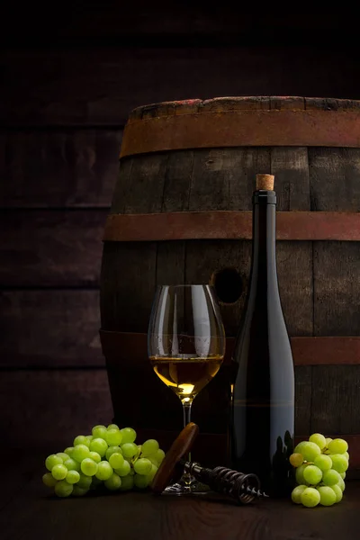 Weißweinflasche und Weinglas auf Holzfass — Stockfoto