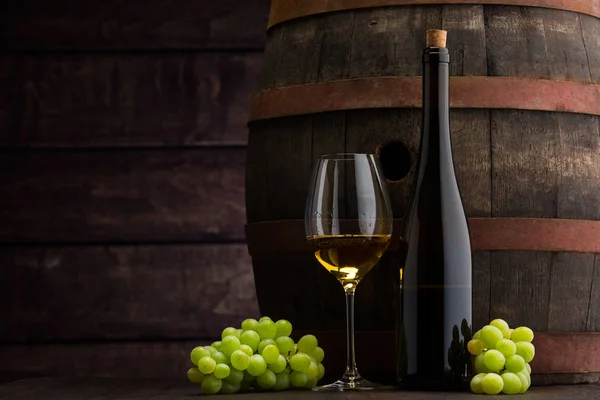 Weißweinflasche und Weinglas auf Holzfass — Stockfoto