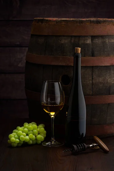 Vit vin flaska och vinglas på wodden fat — Stockfoto