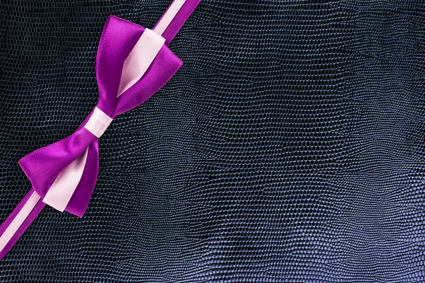 ピンクと白のギフトのリボンとヘビ皮パターン テクスチャ上のノットです ギフト ボックスの包装の概念 — ストック写真