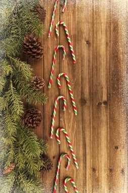 Baston şekerler ve doğal ahşap masa arka planda dallarda Noel ağacı. Doğrudan yukarıdaki.