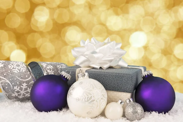 关闭在一个圣诞礼品盒与丝带和弓 装饰中的雪和 背景中的博凯灯 — 图库照片