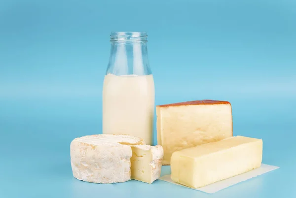 Various fresh dairy products isolated on blue background. Cheese, milk and butter.