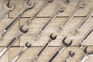 Hemen üstüne beyaz bir ahşap tahta çapraz yoluyla elden anahtarları kümesi. İnşaat kavramı.