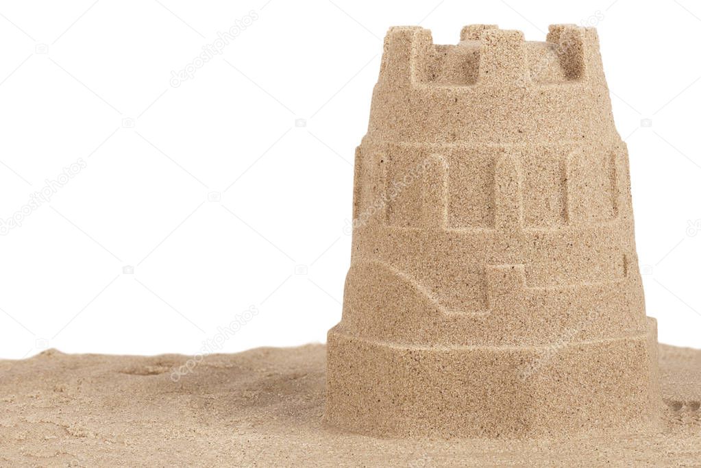 Close up on a sand castle on the beach, isolated on white background. Travel concept. Copy space for your text or image.