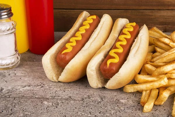 桌子上有一堆热狗和炸薯条 快餐店的概念 — 图库照片