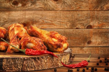 Tavuk kanadı kırmızı pul biber ve karabiber ahşap masa üzerinde sıcak. Arka planda ahşap plakalar.