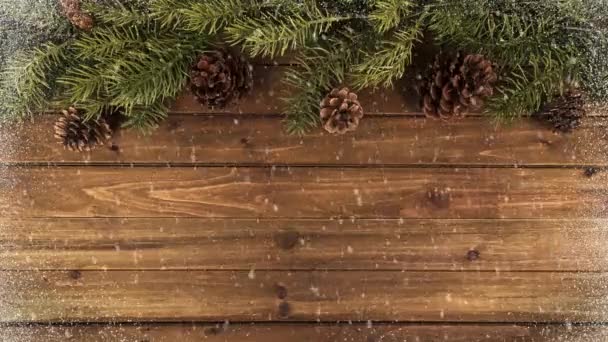 圣诞树树枝在天然木桌上的背景和下降的雪 正上方 — 图库视频影像