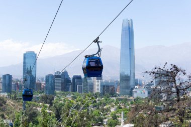 Santiago de Şili şehir manzarası ön planda bir teleferik var. Las Condes bölgesindeki Sanhattan olarak bilinen finans bölgesindeki modern binaların manzarası. Costanera kulesi Güney Amerika 'daki en yüksek gökdelendir.