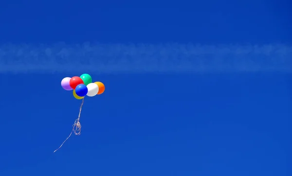 Färgglada ballonger i den blå himlen — Stockfoto