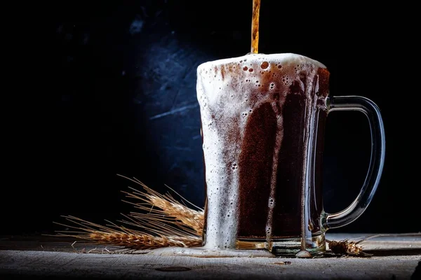 Close up of beer in glass with barley on on dark background . — Stock Photo, Image