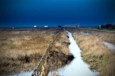 Bir yol yanında mudflats bir çit peyzaj