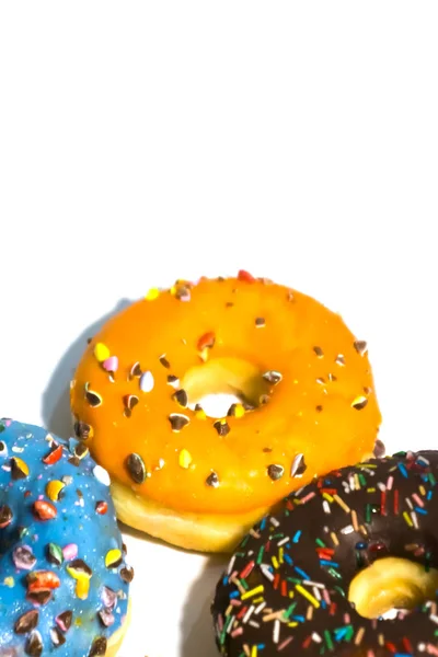 Süße leckere Donuts mit bunten Streusel isoliert auf weißen bac — Stockfoto