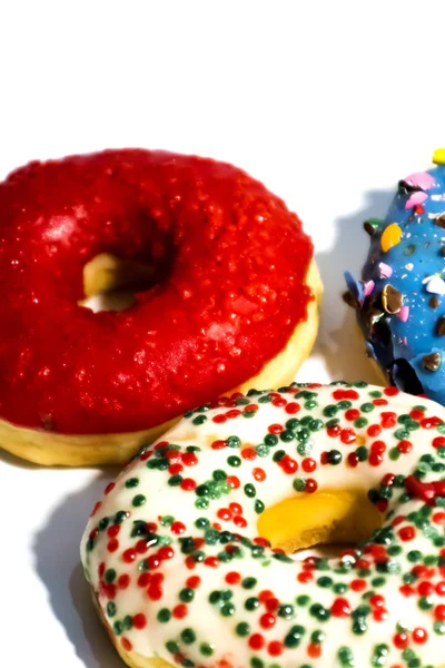 Donuts sucrés savoureux avec des saupoudres colorées isolées sur bac blanc — Photo