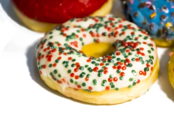 Süße leckere Donuts mit bunten Streusel isoliert auf weißen bac — Stockfoto