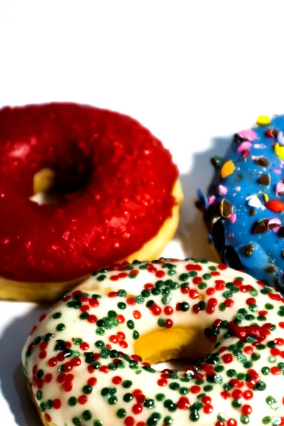 Süße leckere Donuts mit bunten Streusel isoliert auf weißen bac — Stockfoto