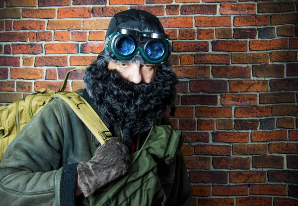 Steampunk man med ryggsäck, skägg, hatt och glasögon på bakgrunds — Stockfoto