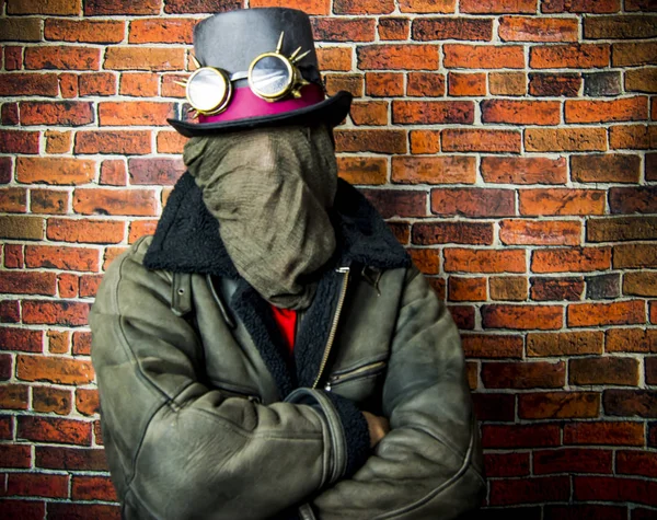 Steampunk człowiek z ukrytą twarzą, kapelusz i okulary na tle — Zdjęcie stockowe