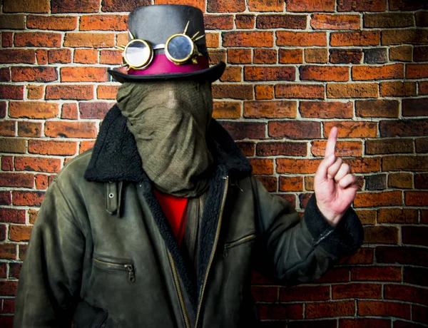 Steampunk człowiek z ukrytą twarzą, kapelusz i okulary na tle — Zdjęcie stockowe