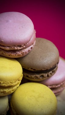 Kırmızı arka planda izole edilmiş renkli makaronlar, tipik Fransız yemeği.