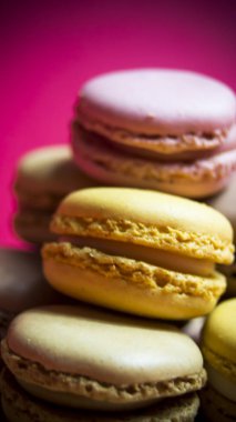 Ahşap tabakta izole edilmiş renkli makaronlar, tipik Fransız yemekleri.