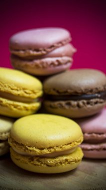 Ahşap tabakta izole edilmiş renkli makaronlar, tipik Fransız yemekleri.