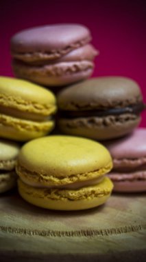 Ahşap tabakta izole edilmiş renkli makaronlar, tipik Fransız yemekleri.