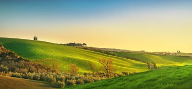 Maremma kırsal, günbatımında inişli çıkışlı tepeler, ağaçlar ve küçük bir göl. Bibbona, Toskana, İtalya. Europe.
