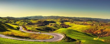 Tuscany manzara, saç tokası bend yol ve yeşil alan, gündoğumu. Volterra İtalya Europe