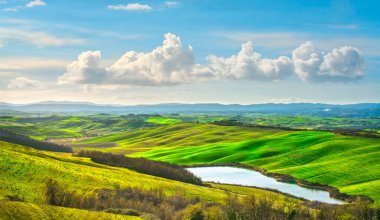 Tuscany landscape, small lake, green and yellow fields in Crete Senesi. Italy, Europe. clipart