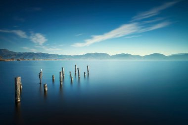 Ahşap iskele ya da iskele kalıntıları ve gün doğumunda göl. Uzun pozlama. Massaciuccoli Gölü. Torre del Lago Puccini, Versilia, Toskana, İtalya, Avrupa