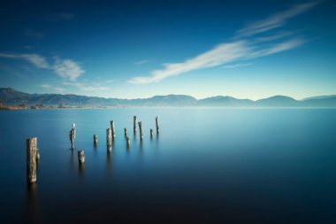 Wooden pier or jetty remains and lake at sunrise. Long Exposure. Massaciuccoli lake. Torre del Lago Puccini, Versilia, Tuscany, Italy, Europe clipart