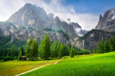 Colfosco yakınlarındaki Pisciadu şelalelerine uzanan manzaralı dağ yolu. Yeşil çayırlar, kozalaklı ormanlar ve yüksek kireçtaşı zirveleri, Güney Tyrol, İtalya