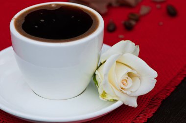 Sıcak bir içecek bir fincan kahve kırmızı peçeteye, eski bir ahşap arka plan, gıda olduğunu.