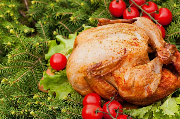 Baked turkey with cherry tomatoes on a Christmas background. Natural food cooked on the grill.