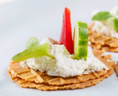 Peynir, otlar, tatlı kırmızı biber, hafif bir arka planda salatalık ile tuzlu waffle.